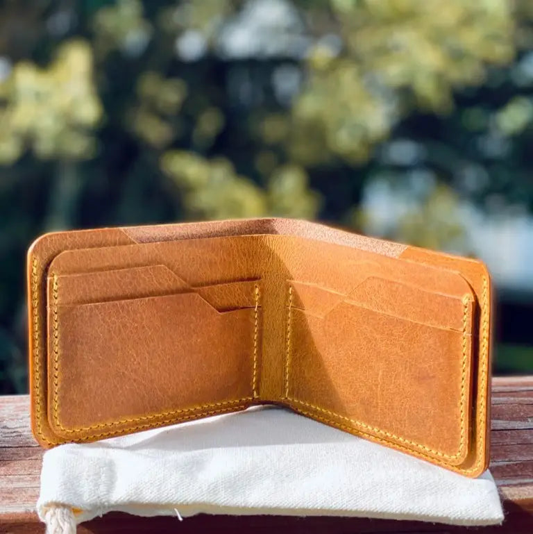 Yellow leather wallet on a wooden surface with a blurred natural background
